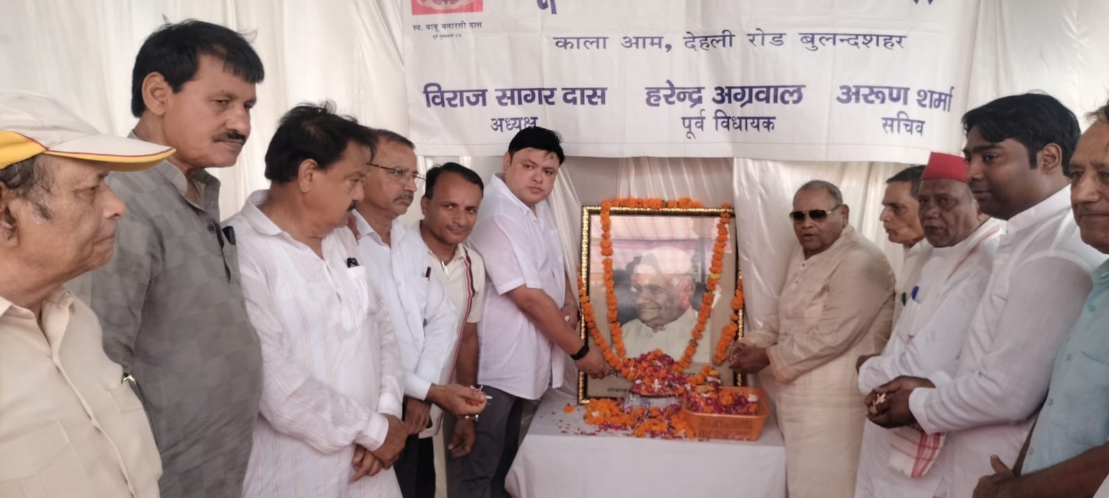 नगर में पूर्व मुख्यमंत्री बाबू बनारसी दास के चित्र पर श्रद्धासुमन अर्पित करते लोग। स्रोत: आयोजक