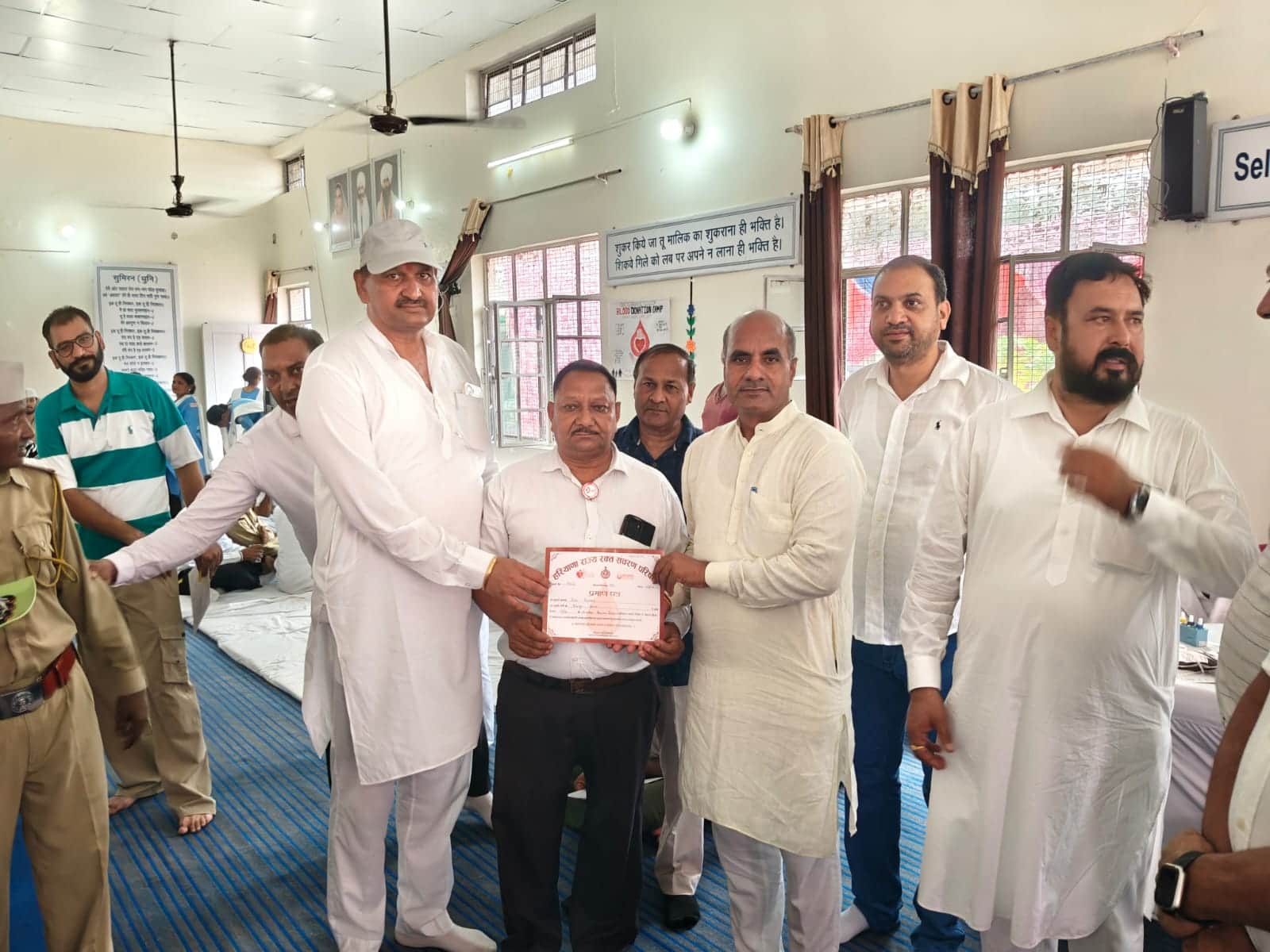 रक्तदाताओं को सम्मानित करते मुख्य अतिथि व अन्य। आयोजक