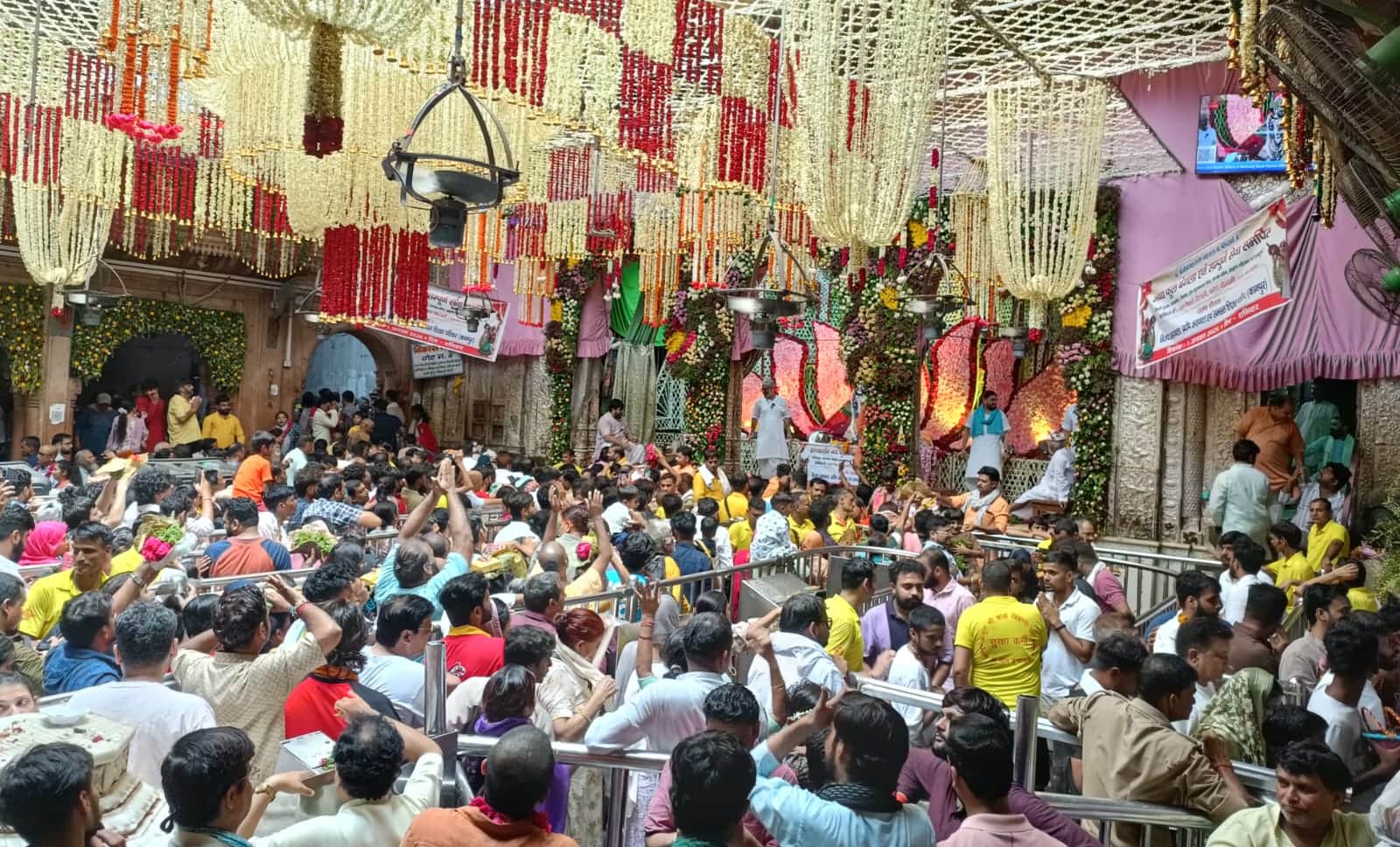 रेलिंग के बीच ठाकुर श्रीबांकेबिहारी के दर्शन करते हुए श्रद्धालु। 