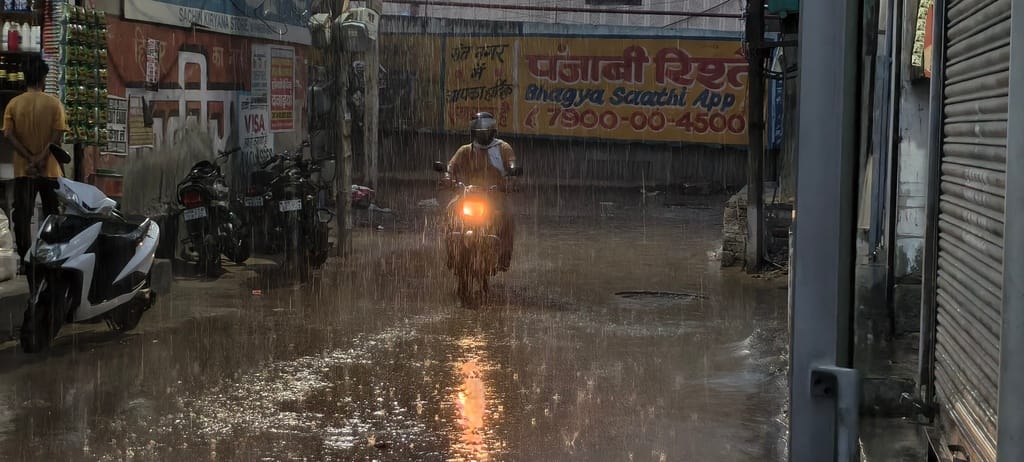 बरसात के दौरान संत नगर से गुजरते लोग।