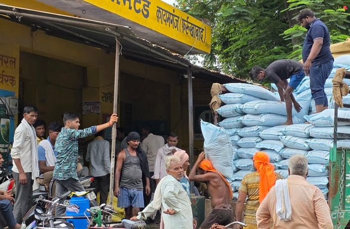 फोटो-5 इफको केंद्र पर खाद उतारते मजदूर और लगी किसानों की भीड़। संवाद