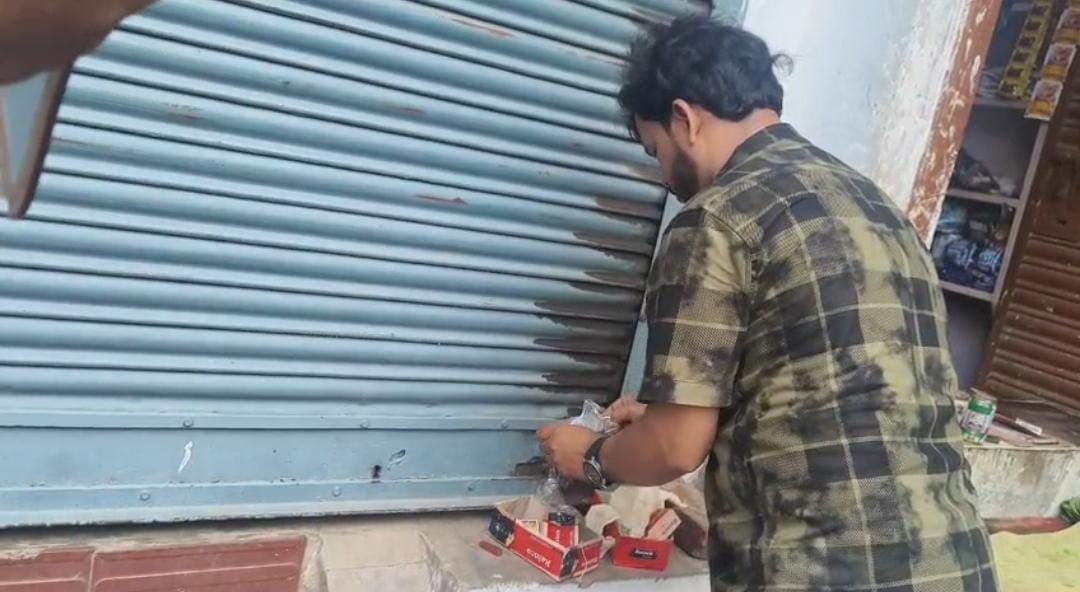  इकौना कस्बे में क्लीनिक को सील करता कर्मी।