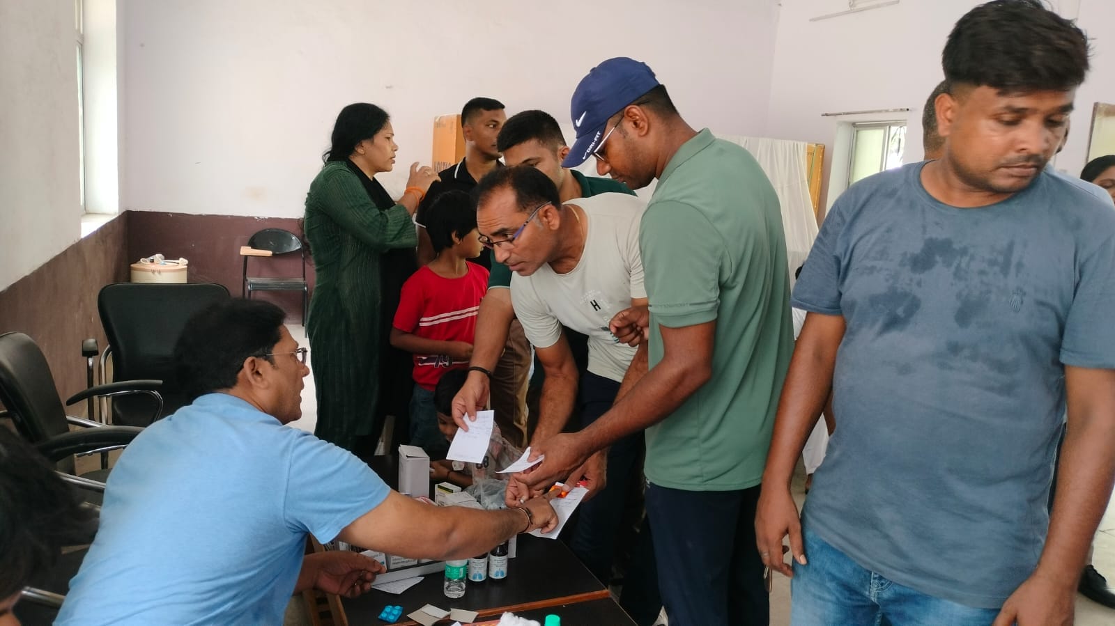शहर के छावनी लाइन में आयोजित वामा वेलनेस शिविर में जांच के बाद दवा लेते पुलिसकर्मी व उनके परिजन