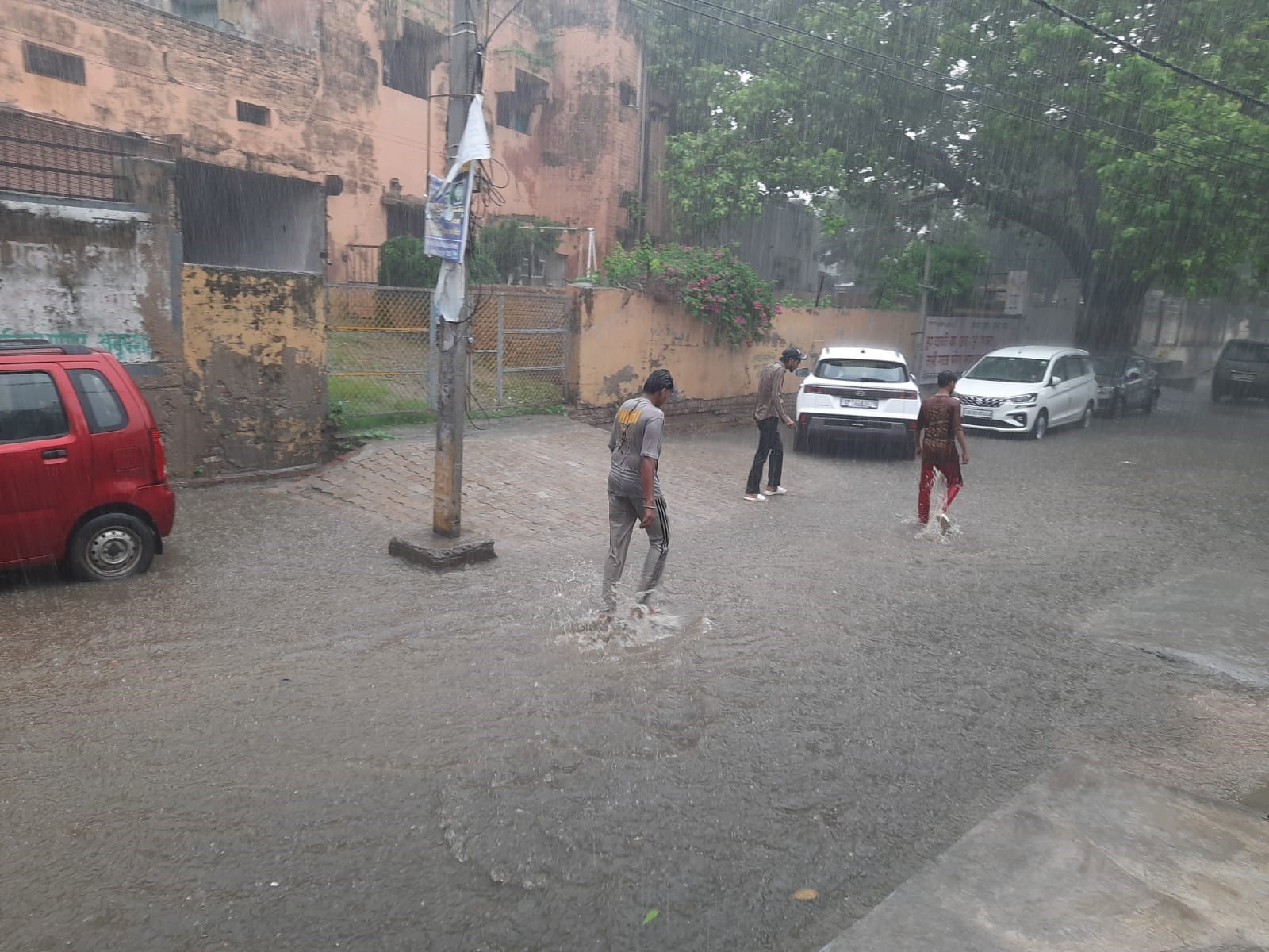 अनूपशहर में बारिश के बीच जाते युवक। संवाद