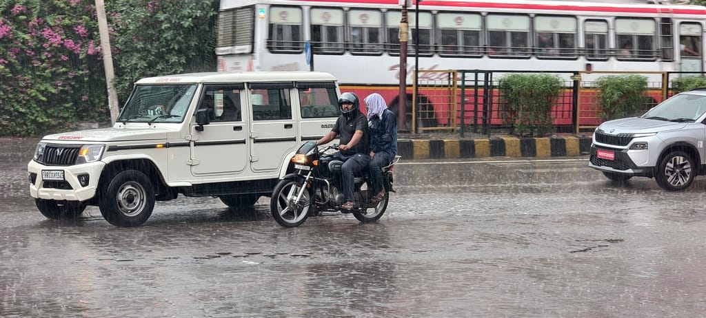 बरसात के दौरान दिल्ली रोड से गुजरते हैं वाहन चालक। 