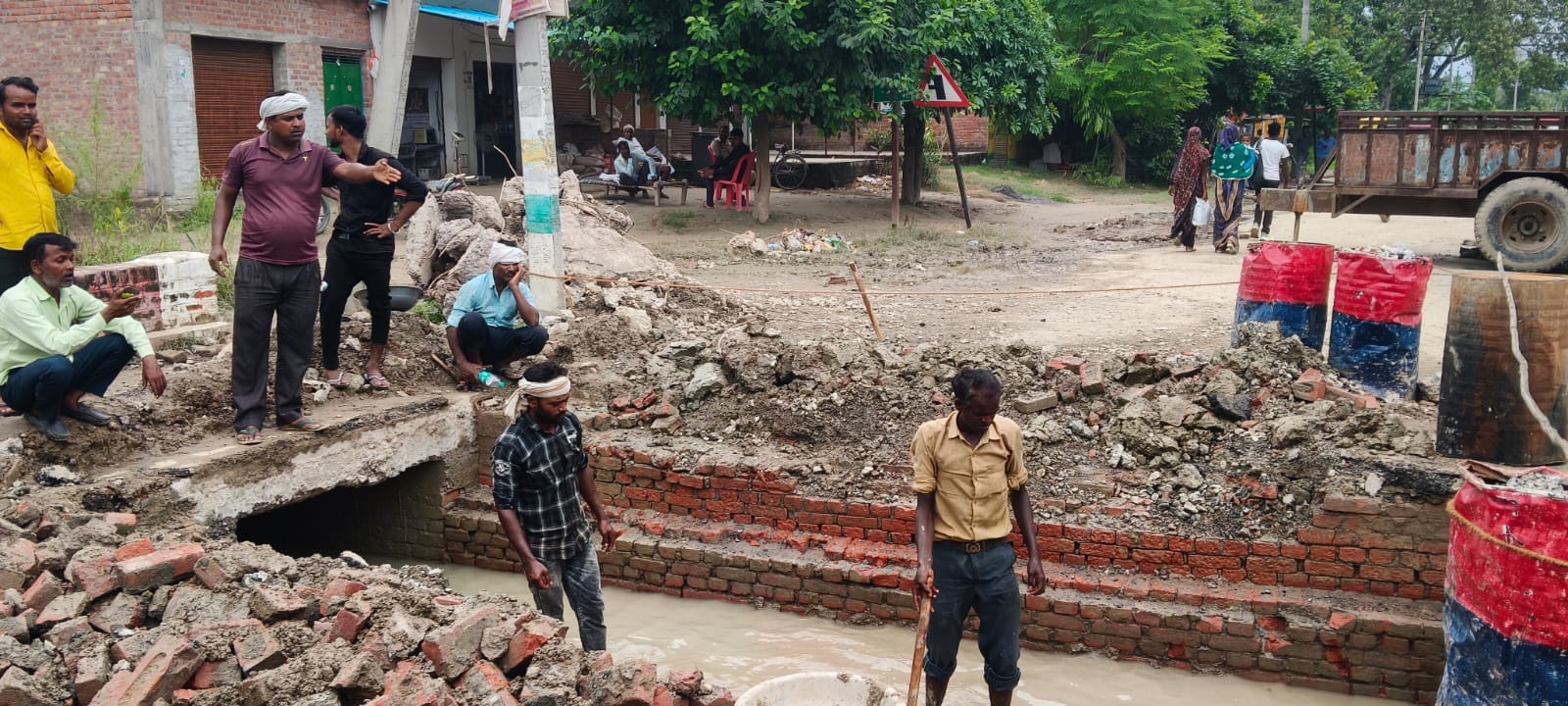फोटो 02: पिलखना के पास बरहस रजबहा पर क्षतिग्रस्त पुलिया पर काम करते मजदूर। संवाद &nbsp;