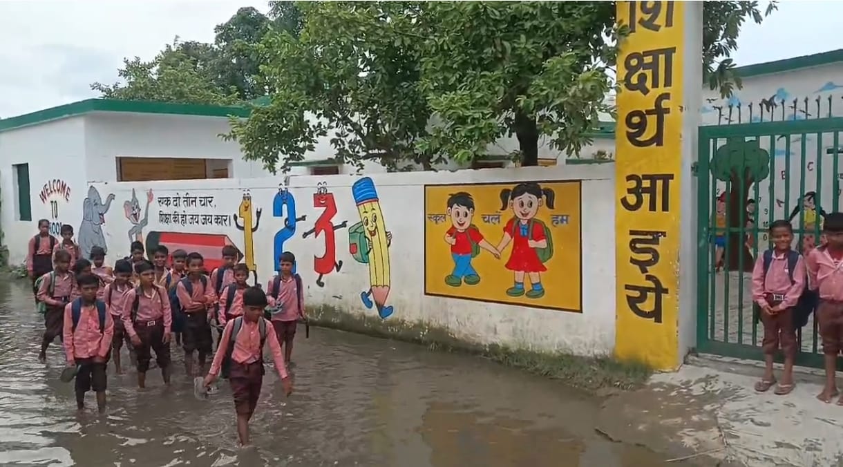 रास्ते में भरे पानी से गुजरते छात्र। स्रोत : वीडियो ग्रैब