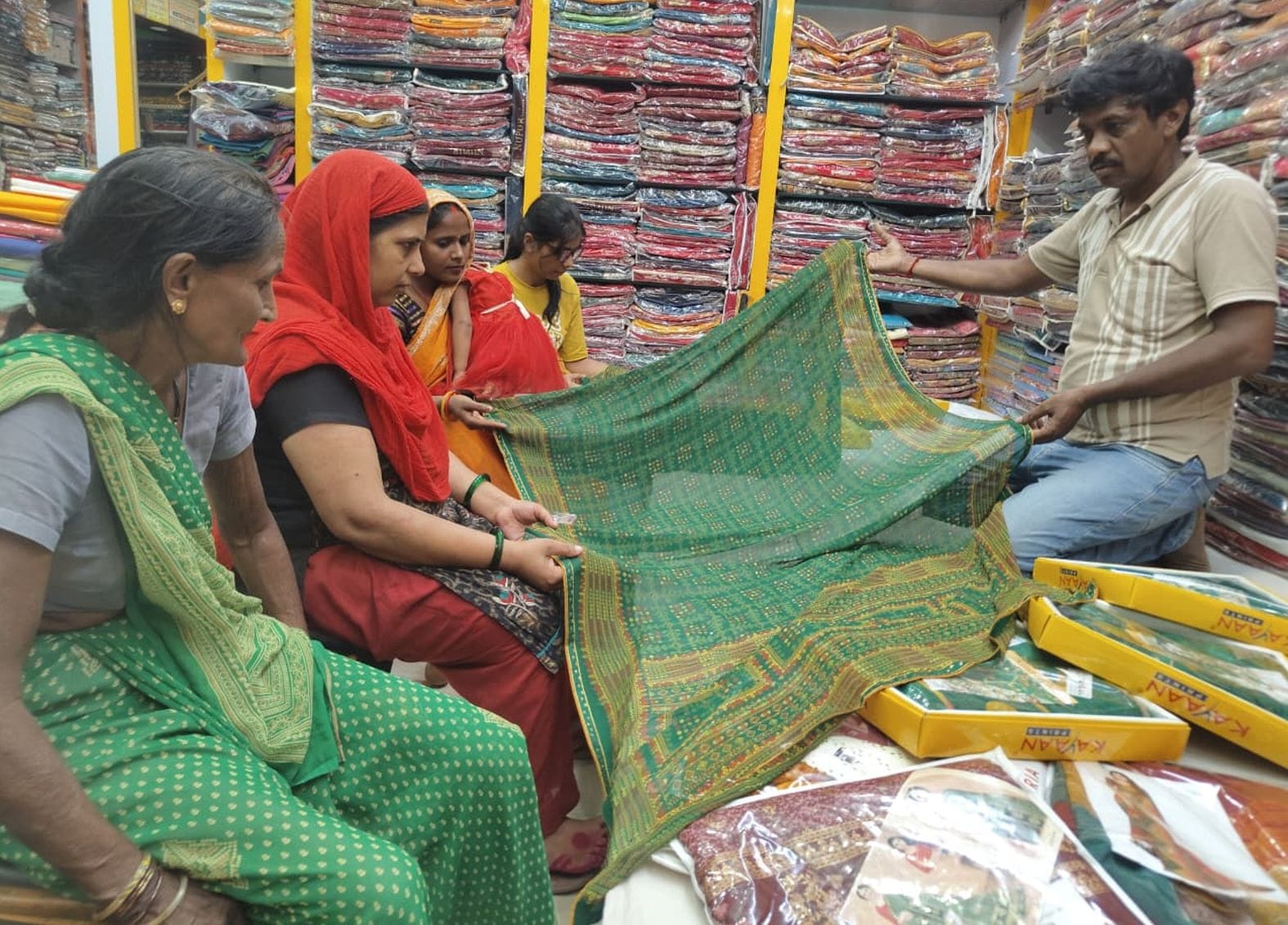 साड़ियां देखतीं महिलाएं 