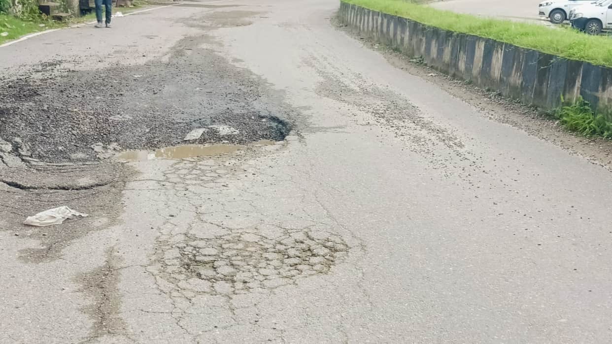 Road surfacing begins to peel off; gravel scattered on the road increases the risk of accidents.