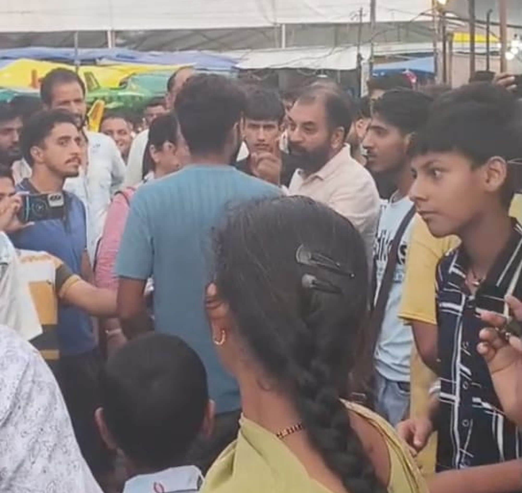 चंबा मिंजर मेले के दौरान झूले के कम चक्कर लगवाने को लेकर संचालक का घेराव कर   बात करते लोग।संवा