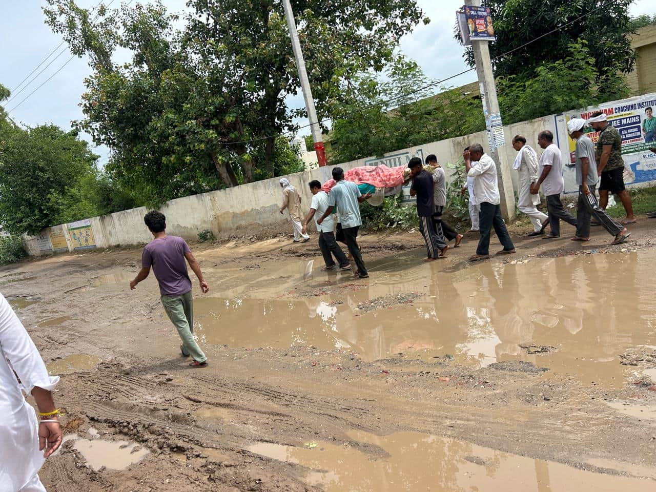 गंदे पानी से अर्थी को लेकर गुजरने ग्रामीण।