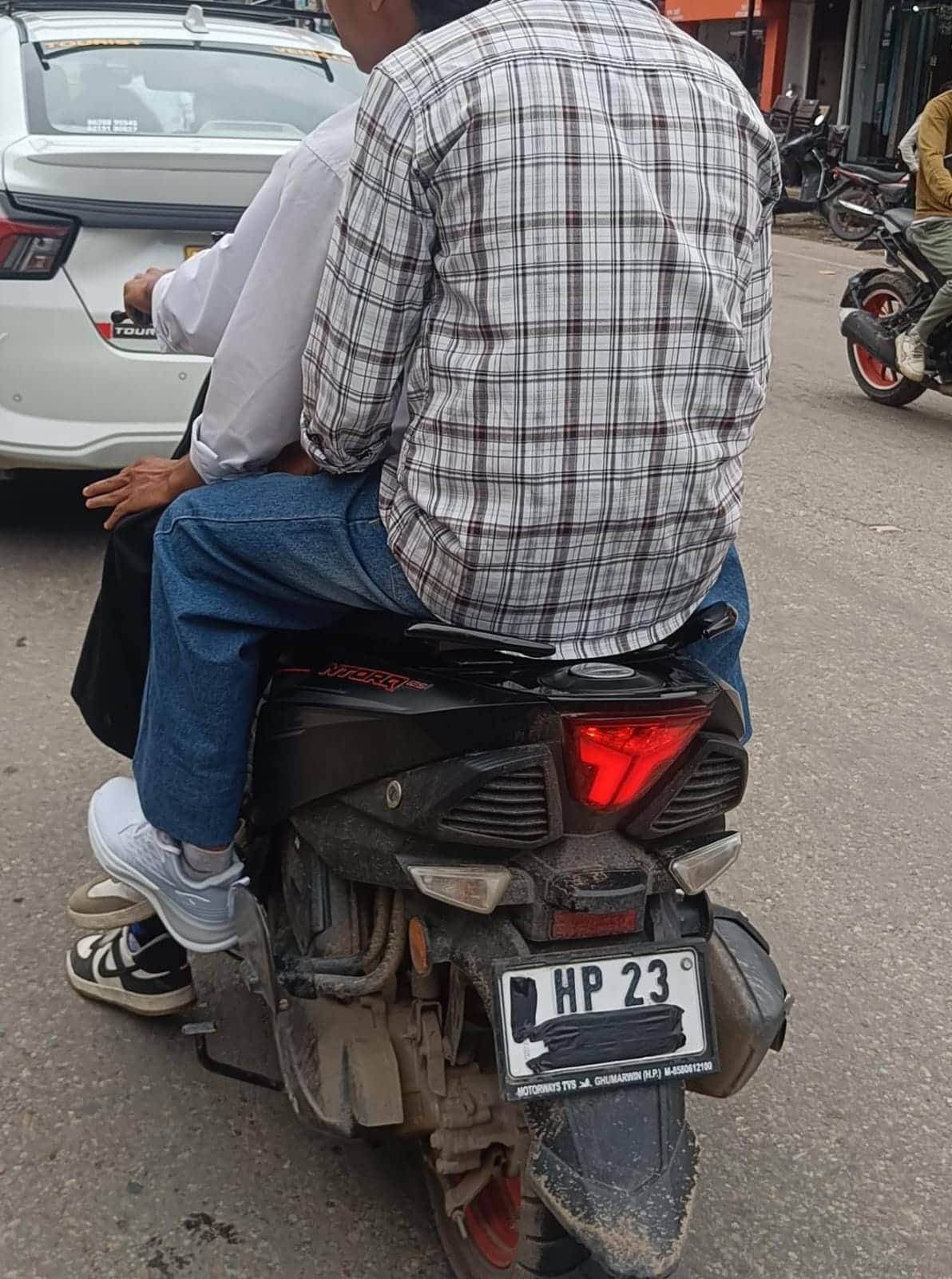 घुमारवीं क्षेत्र में स्कूटी पर सवार तीन युवक और नंबर प्लेट ढकी हुई। स्रोत: जागरूक पाठक