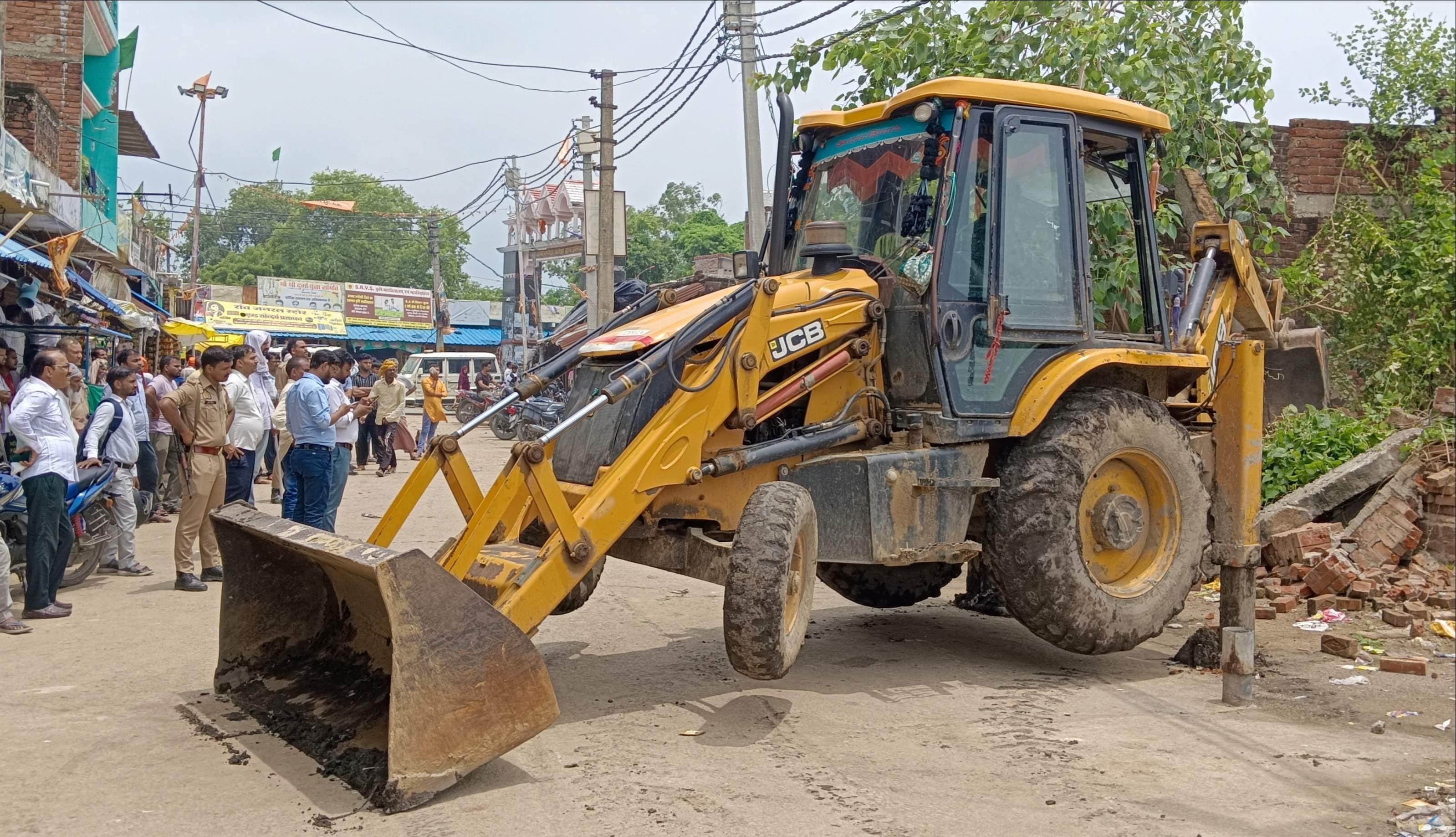 इलिया में अमृत सरोवर से अतिक्रमण हटवाते अधिकारी। संवाद
