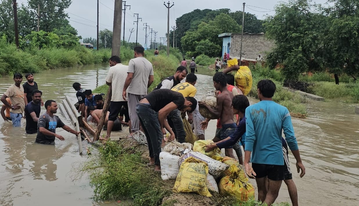 Flood-like conditions in the village after a distributary canal breaches; people forced to leave their homes.