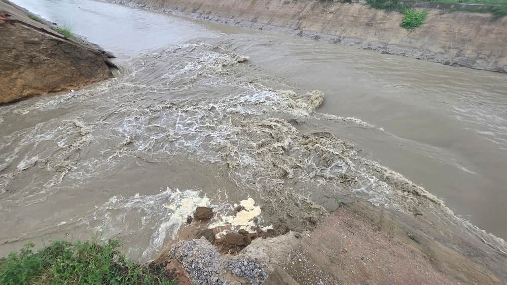 टांडा के सुंथर गांव में रजवाहा की पटरी कटने के बाद बहता पानी। संवाद