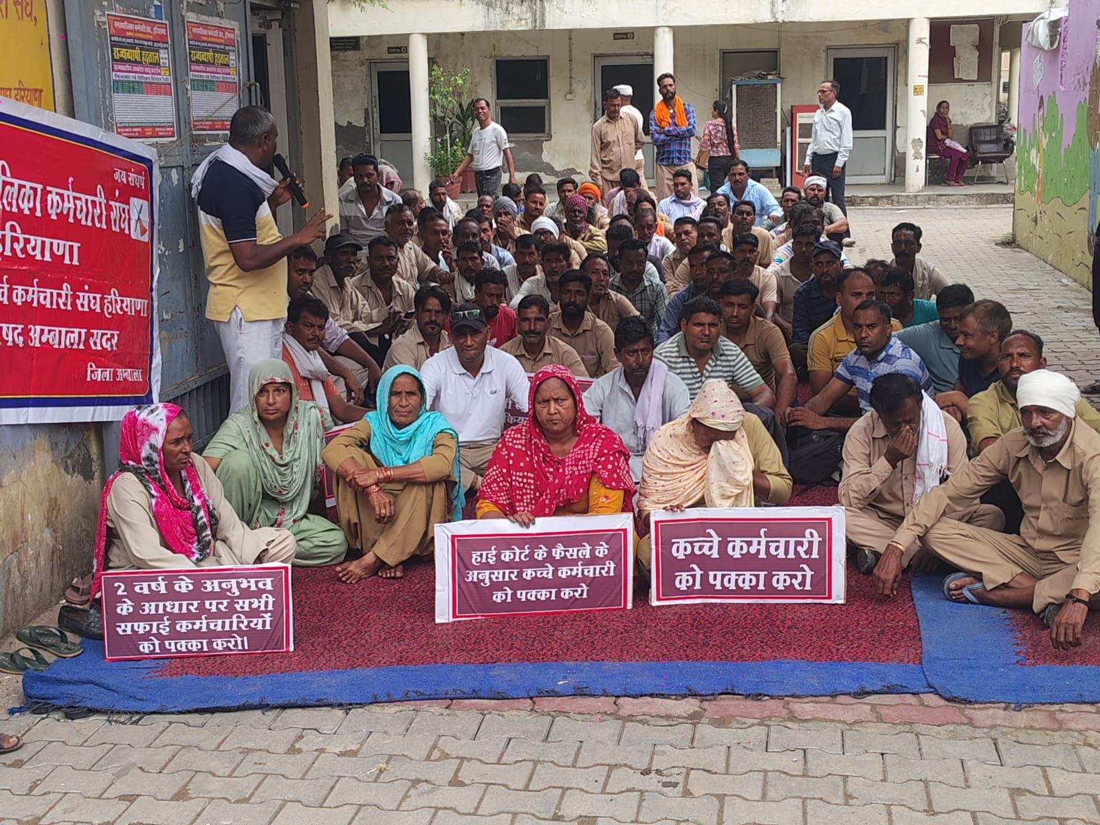 अंबाला छावनी के नगर परिषद कार्यालय के गेट पर बैठ प्रदर्शन करते सफाई कर्मचारी। संवाद