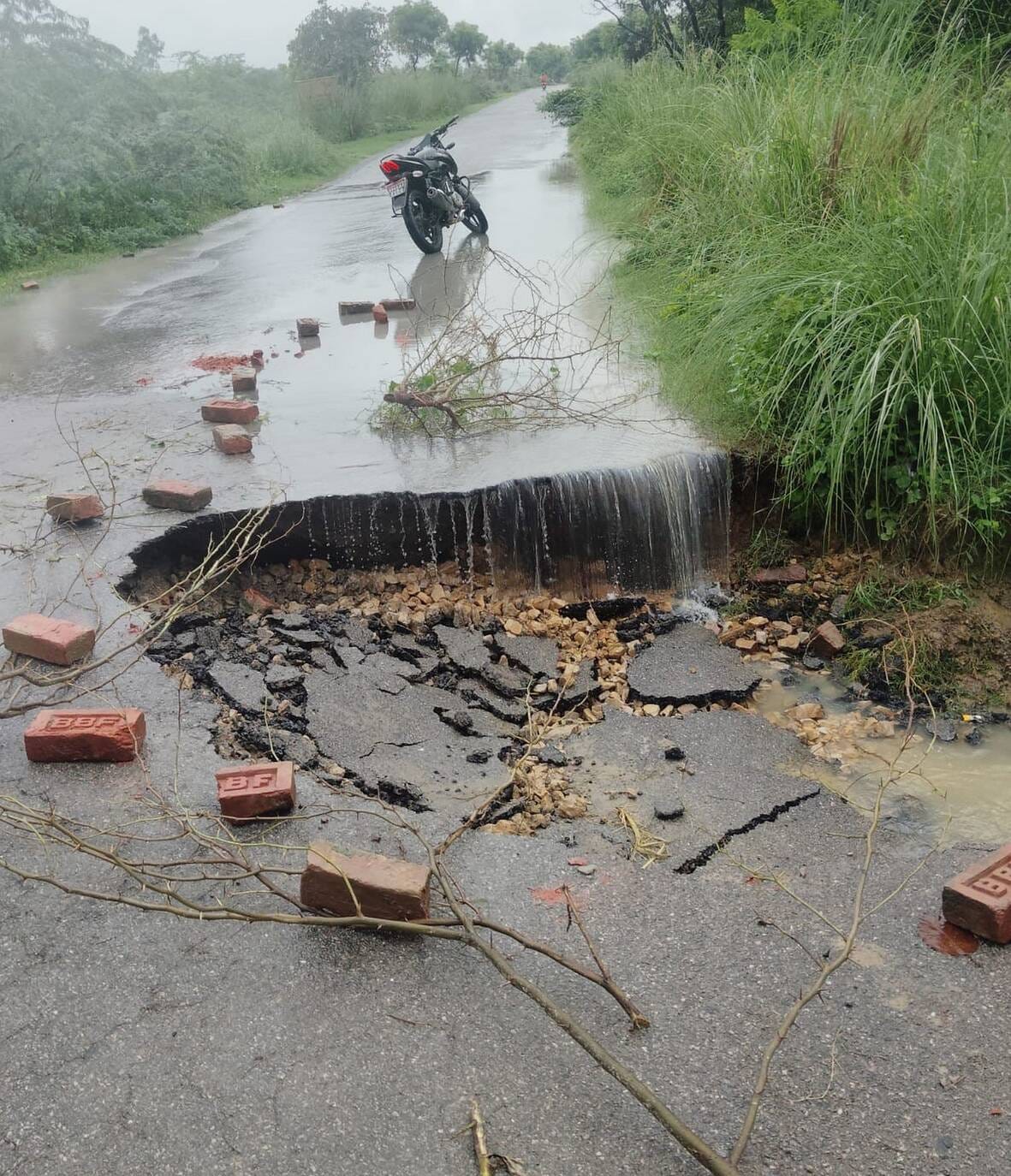 Access road washed away in rain; traffic disrupted.