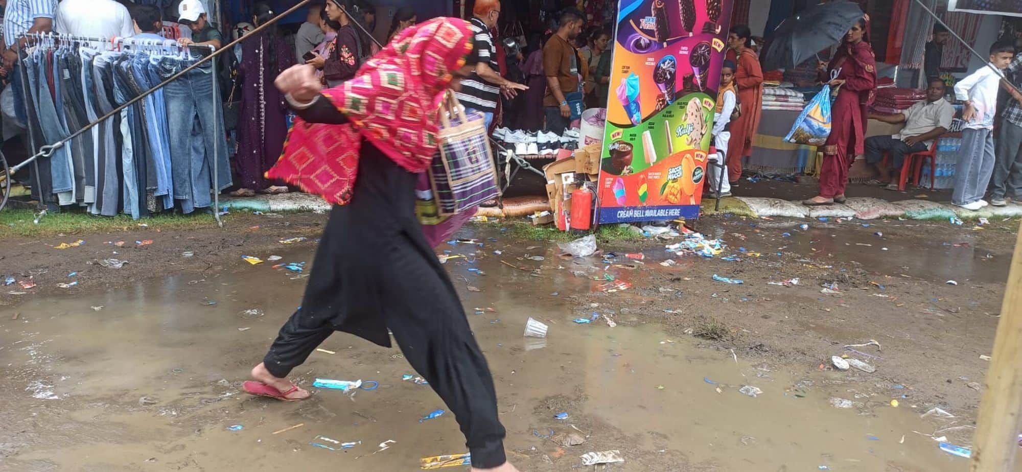 चंबा चौगान में बारिश के दौरान डोम के पास कीचड़ के बीच बचकर निकलती महिला।संवाद