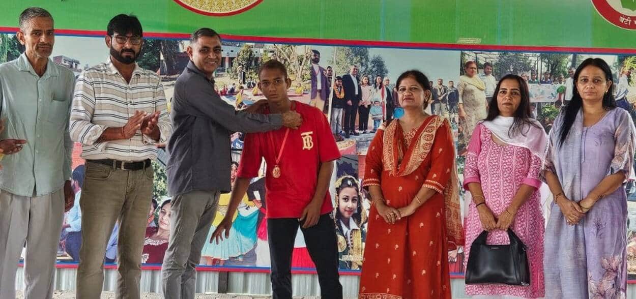 फोटो - राजकीय उच्च विद्यालय माहरा में विजेता खिलाड़ी को सम्मानित करते हुए शिक्षक। स्रोत  - प्रवक
