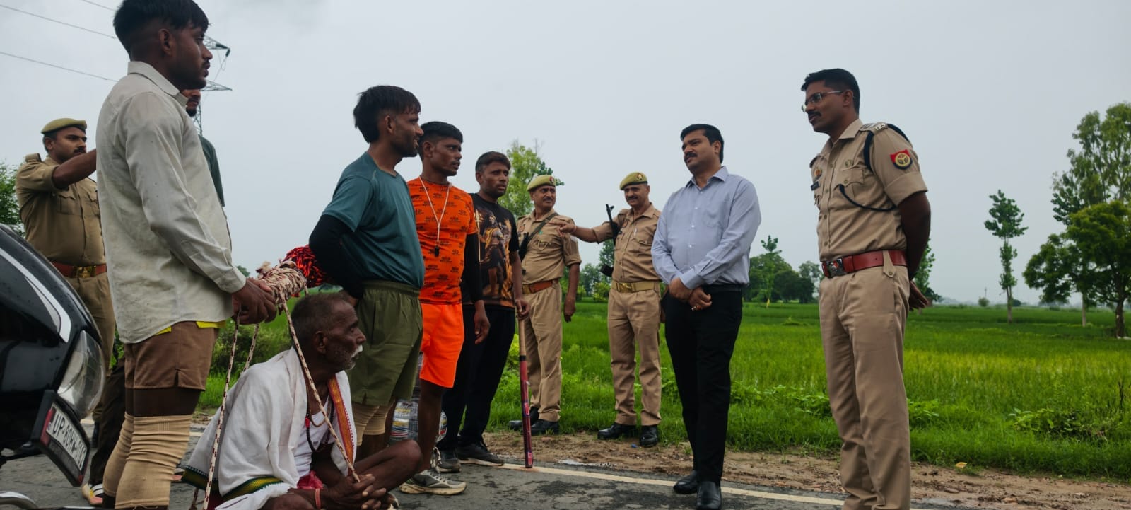 पिता को कंधों पर ले जाते कांवडियों से बात करते डीएम अरविंद सिंह व एसएसपी डॉ. इलामारन। स्रोत सूच