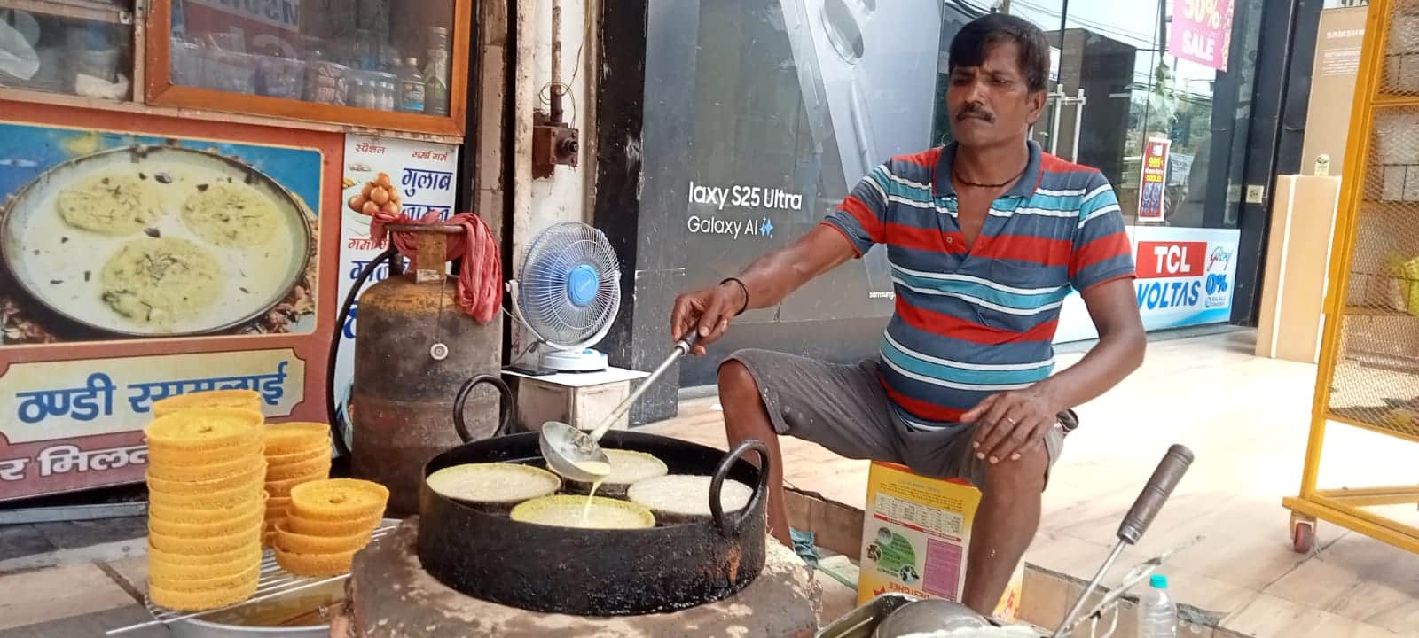 शहर के एक मिष्ठान भंडार पर घेवर बनाता कारीगर। संवाद