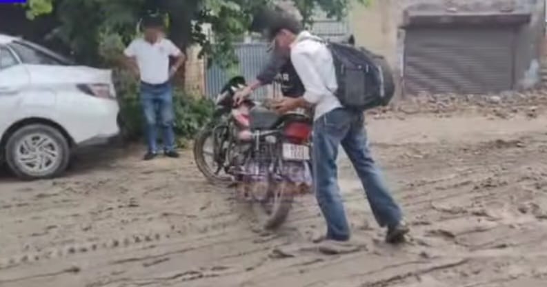 फोटो 08एसएफडीएम1खानसर चौक पर कीचड़ होने के कारण बाइक से नीचे उतरकर निकलते हुए दो युवक। संवाद 