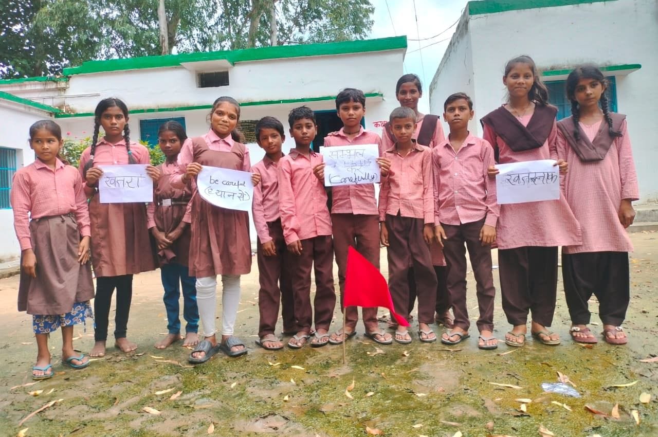 जागरूकता पोस्टर लिए विद्यार्थी।