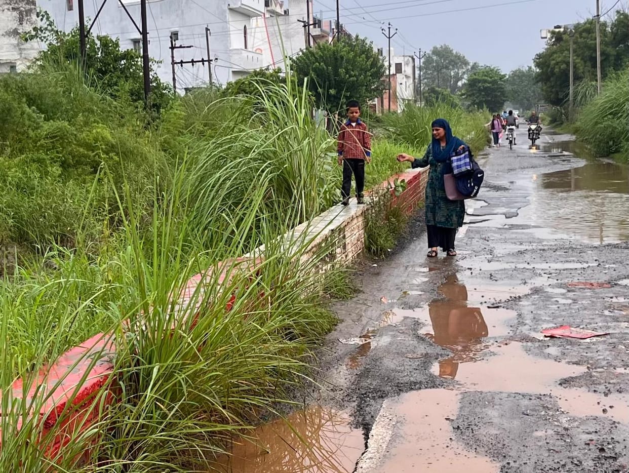 Road crumbles within eight months; students forced to climb a wall to get out.