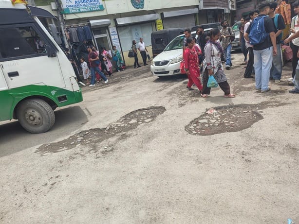 Potholes at the old bus stand and on Mall Road; pedestrians and traders inconvenienced.