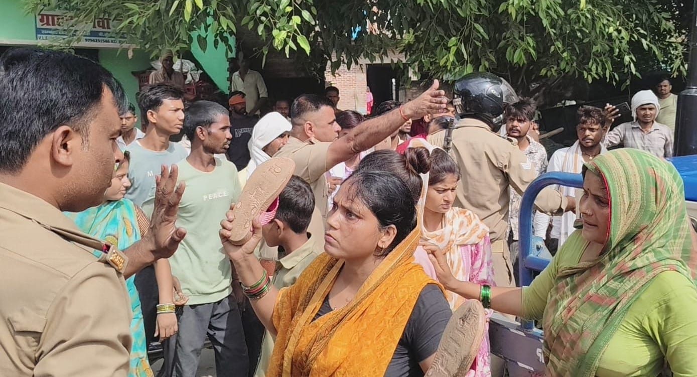 पुलिसकर्मी को चप्पल दिखाती महिला