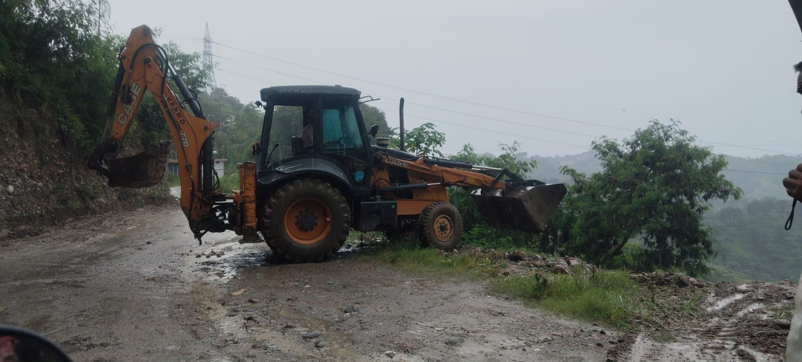 टौणी देवी-ऊहल सड़क मार्ग पर अस्थाई नालियों का निर्माण करती जेसीबी। संवाद