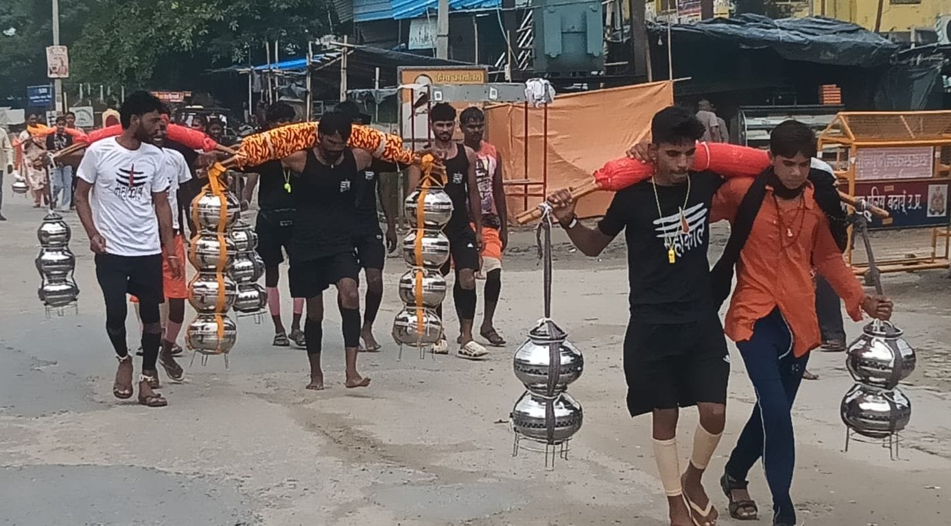 बुजुर्ग दादी को स्नान कराने के लिए जल ले जाते कांवड़िए। संवाद