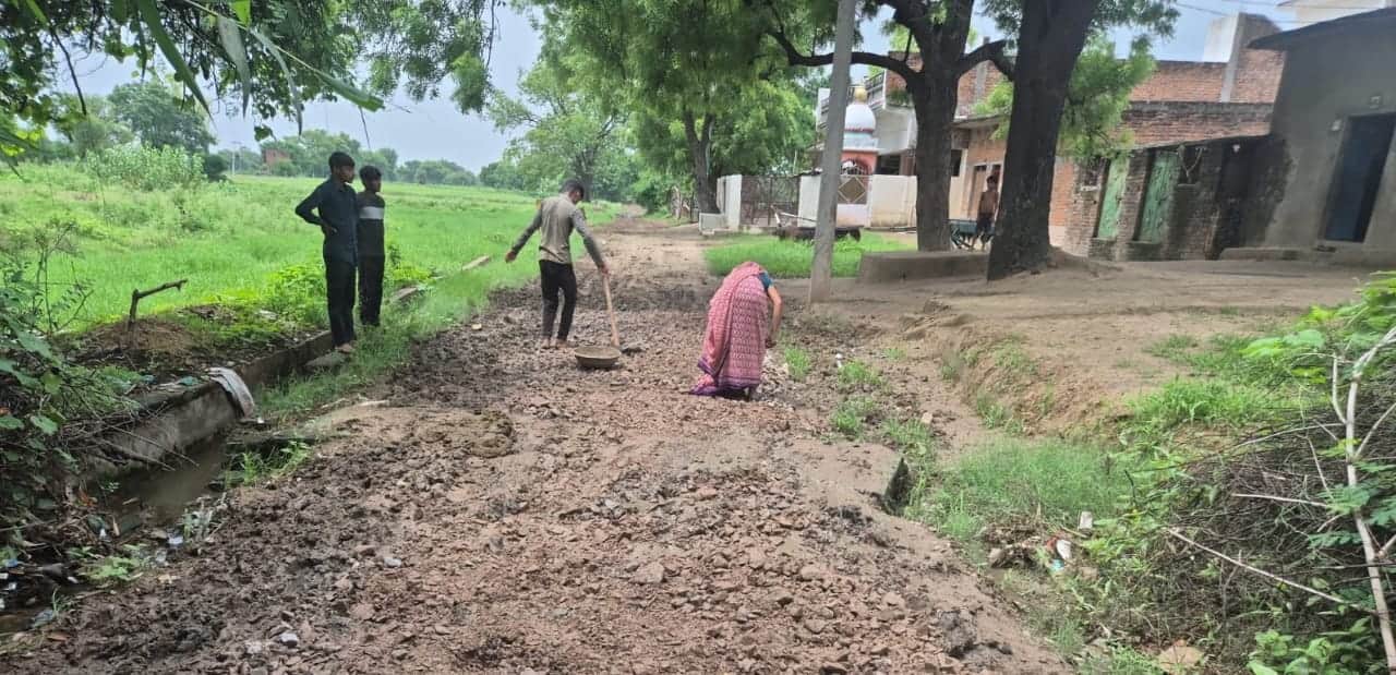 फोटो 7- भिडौरा-गजनी के दलदली मार्ग पर डस्ट, गिट्टी डालते श्रमिक। संवाद