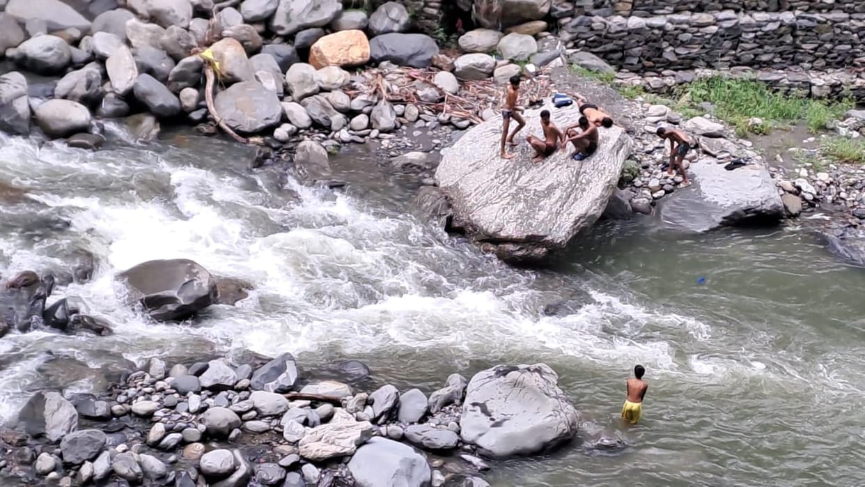 Youths bathing in Sarvari Khad, risking their lives.
