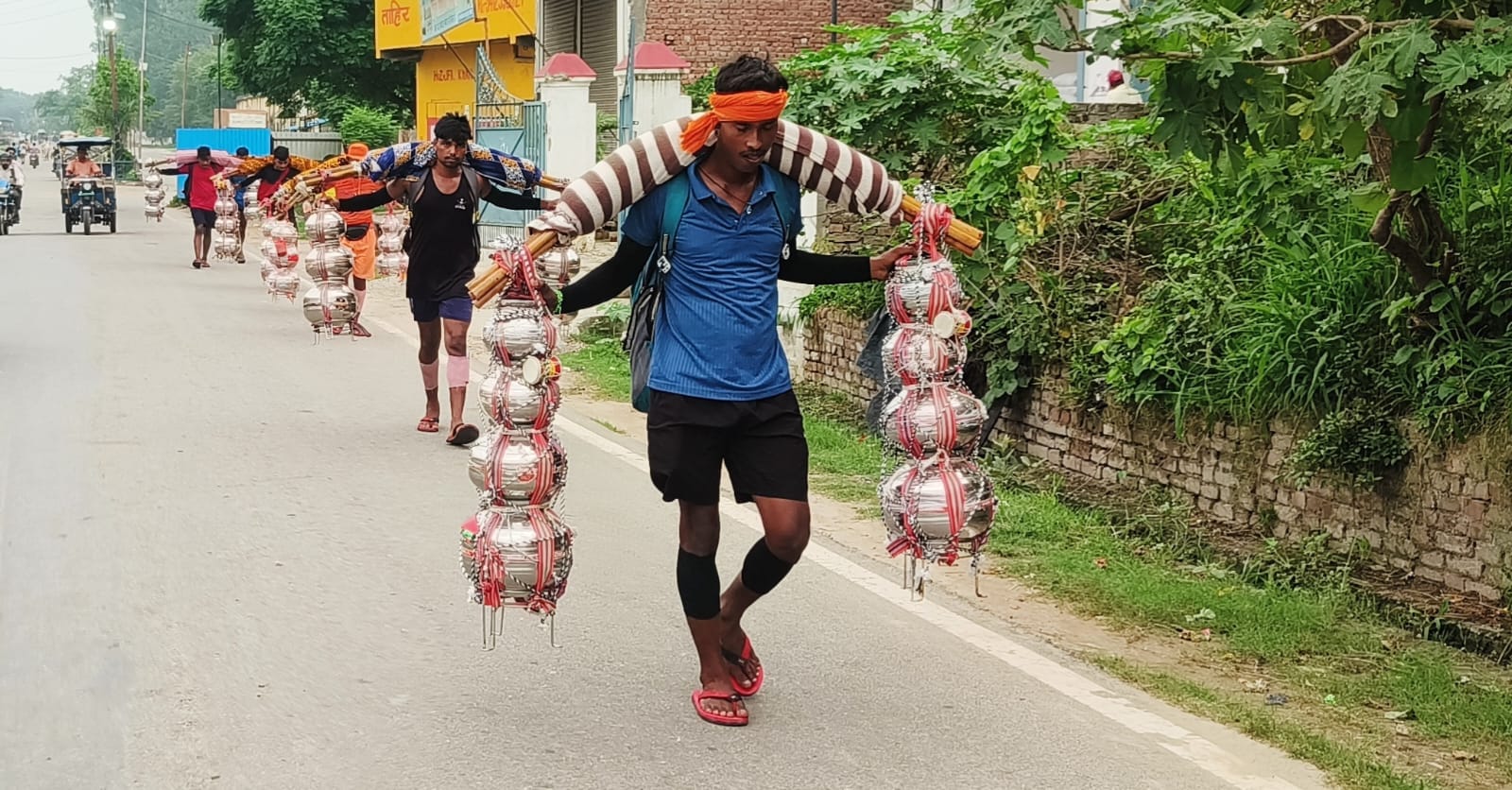 कलश में गंगा जल भरकर नगीना होकर गंतव्य की ओर निकलते रुद्रपुर के शिव भक्तों का जत्था।