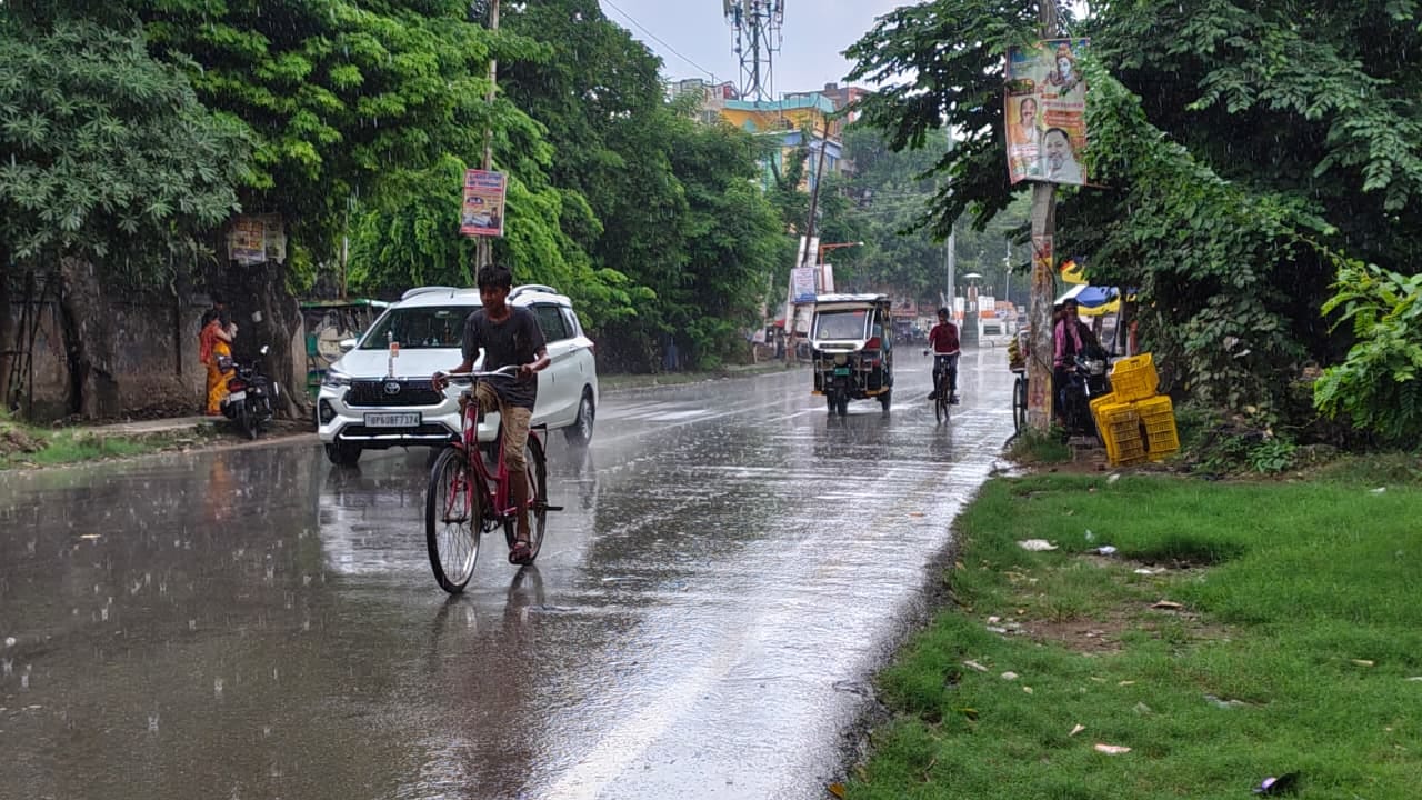 नगर के टीडी कालेज चौराहा पर बारिश के दौरान भींगते हुए साइकिल से अपने गंतव्य को जाता बालक।संवाद