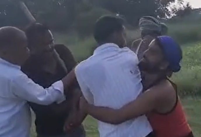Video of village head and his son assaulting a young man goes viral.
