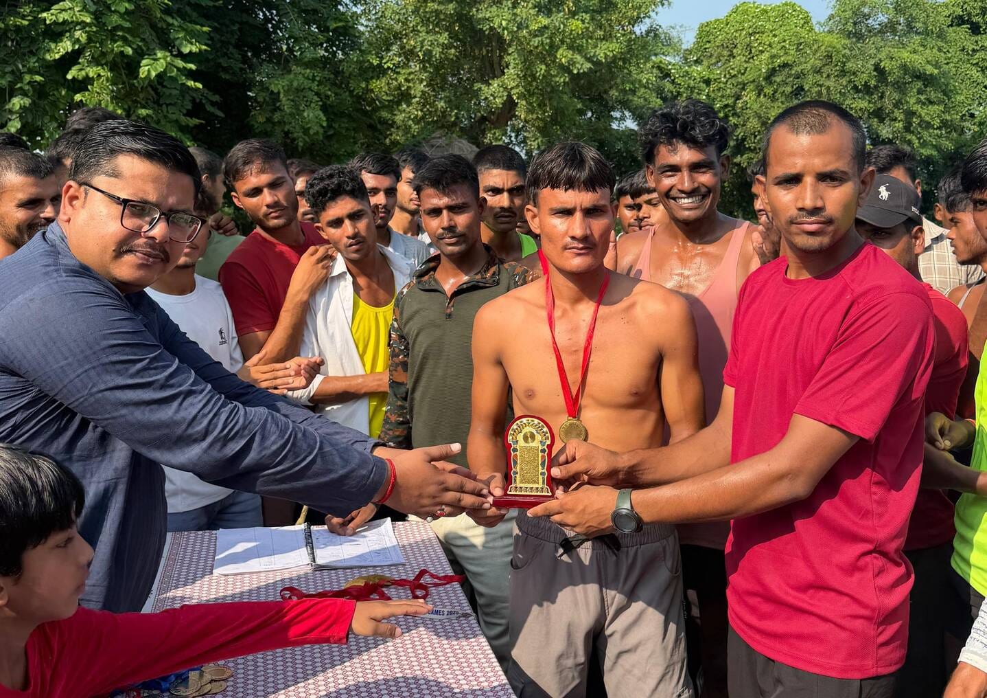 जरीफनगर की दौड़ प्रतियोगिता में धावक को सम्मानित करते अतिथि। संवाद