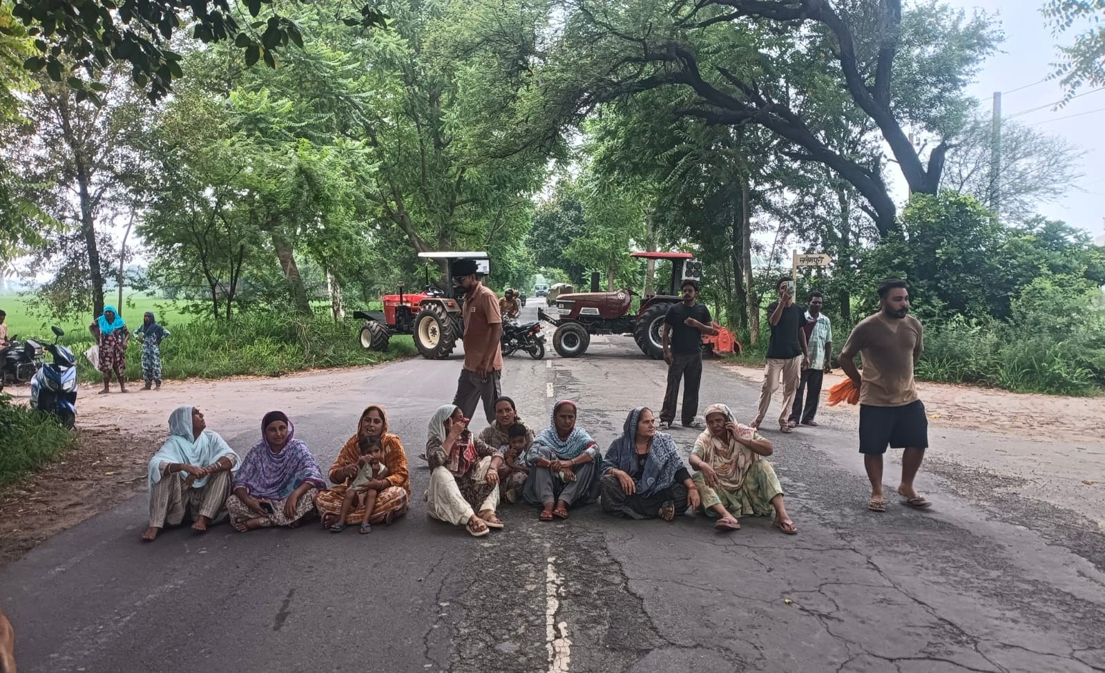 कुलां। बिजली समस्या लेकर कुलां-टोहाना मार्ग पर धरना देती महिलाएं। संवाद