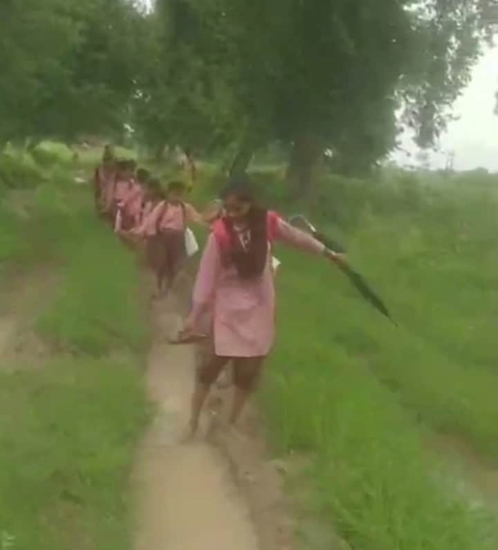 Video goes viral: Students walk to school through the mud, carrying their schoolbags on their backs and their footwear in their hands.