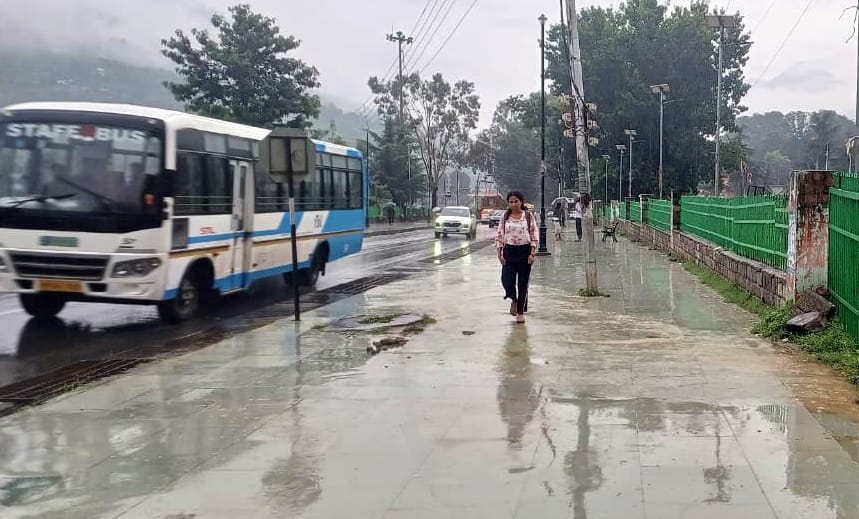 ढालपुर में मालरोड पर बहते पानी के बीच बचते हुए आवाजाही करती युवती। -संवाद