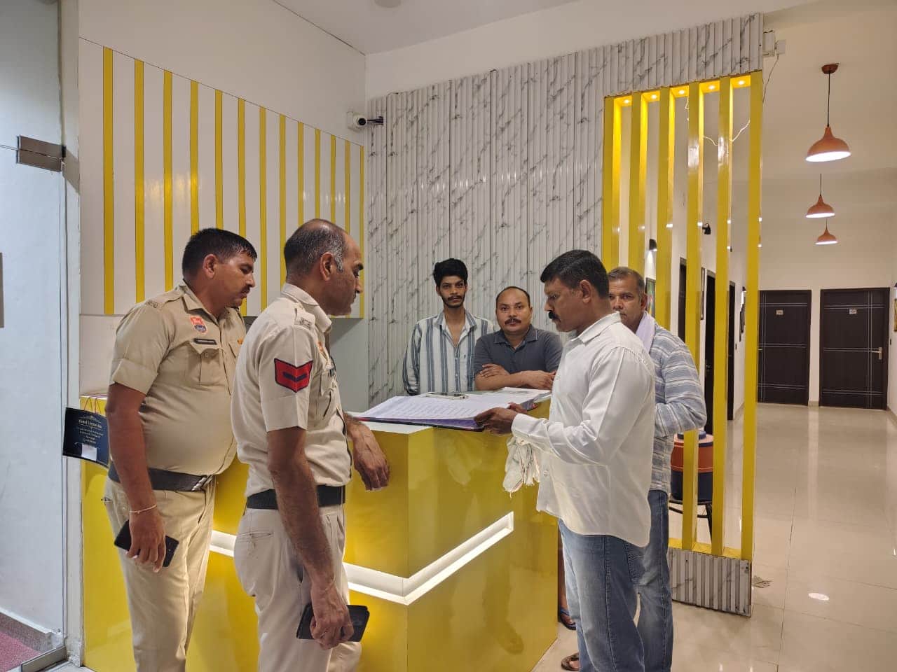 होटल में रिकार्ड की जांच करते पुलिस कर्मचारी। स्त्रोत: पुलिस