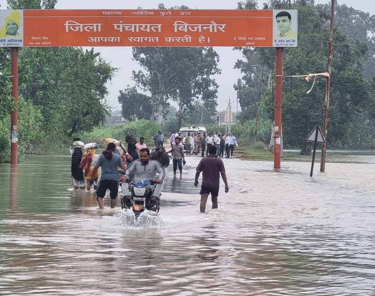 जलीलपुर में बाढ़ के पानी में आवागमन करते गांववासी स्रोत संवाद