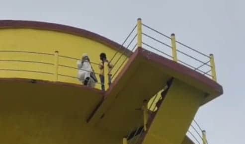 Woman climbs water tank with son, alleging husband has remarried.