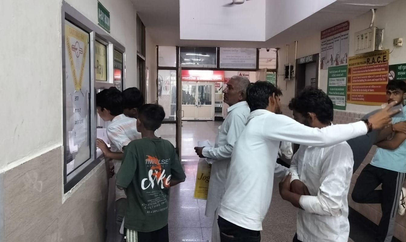 11जेएनडी07: नागरिक अस्पताल की एक्सरे खिड़की पर एक्सरे करवाने के लिए पूछताछ करते मरीज।संवाद