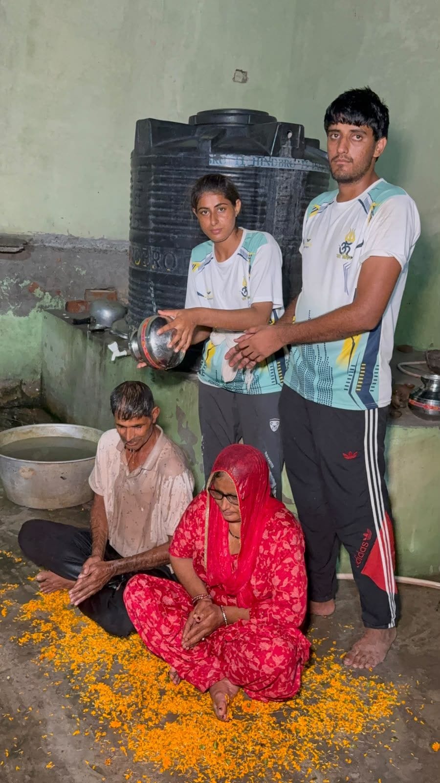 11जेएनडी11: नीशू देशवाल व उसका भाई माता पिता को गंगाजल से मंदिर परिसर में स्नान करवाते हुए। स्र