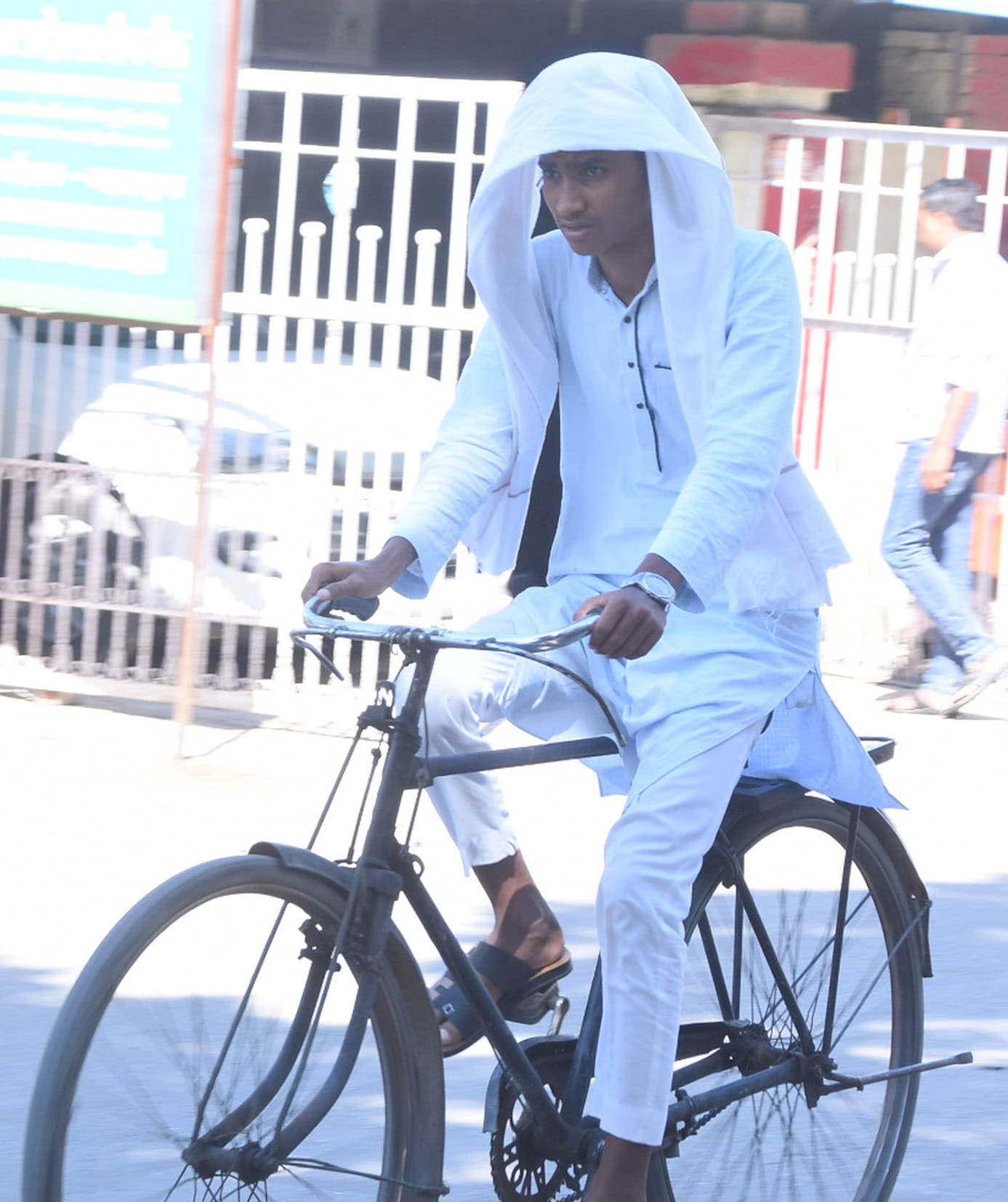  बहराइच में चिलचिलाती धूप में कपड़ा लपेटकर गुजरता युवक।