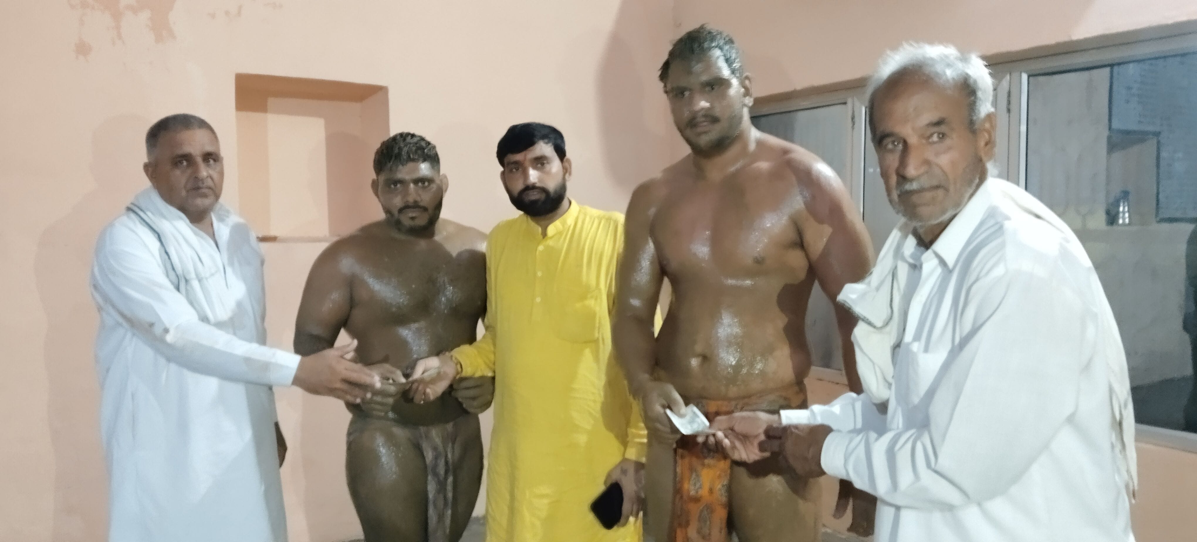 फोटो 03: कुश्ती दंगल में पहलवानों को पुरस्कृत करते हुए मेला कमेटी सदस्य। स्रोत: ग्रामीण