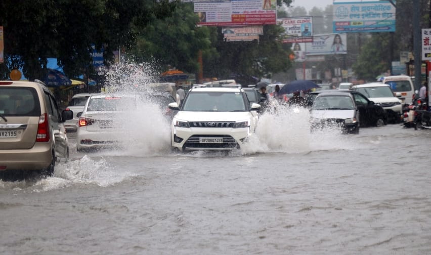 मेरठ पौड़ी हाईवे पर बिजनौर में आदर्श नगर के सामने हुए जलभराव से निकलते वाहन। संवाद