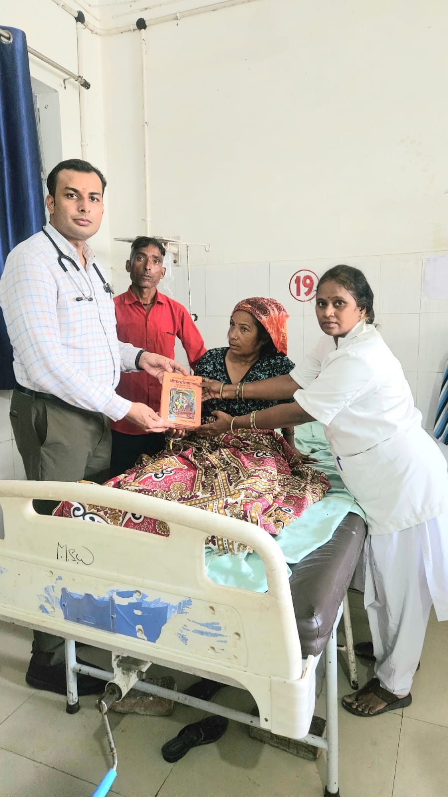 फोटो-22 लोहिया अस्पताल में ऑपरेशन के बाद मरीज को रामचरित मानस भेंट करते डॉ. रोहित तिवारी। स्रोत